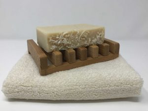 A Sandalwood Scented Coconut Soap Bar on Wood Tray